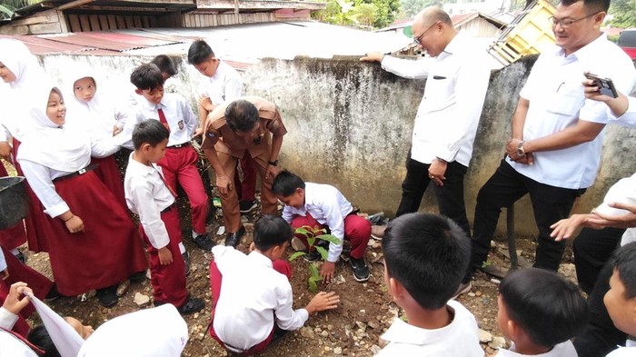 Polres Kuansing mengajarkan anak-anak SD mencintai lingkungan dengan menanam pohon, Selasa (30/9/2025).
