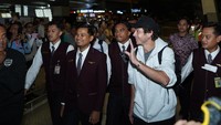 Rossi berjalan menuju pintu keluar bandara dengan pengawalan. Kedatangan sang legenda disambut penggemar. Foto: Dok. Pertamina Lubricants