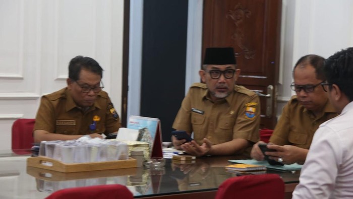 Sekda Jambi Sudirman yang menggunakan kopiah hitam dalam rapat bahas TBC dan MBG