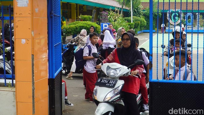 Suasana SDN 01 Gedong Pascakeracunan MBG Orangtua wali murid menjemput siswa SDN 01 Gedong, Pasar Rebo, Jakarta Timur, Selasa (30/9/2025).