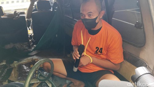 Tersangka Aris saat menunjukkan cara kerja beli Pertalite subsidi dengan tangki mobil yang dimodifikasi, Badung, Bali, Senin (30/9/2025). (Agus Eka/detikBali)