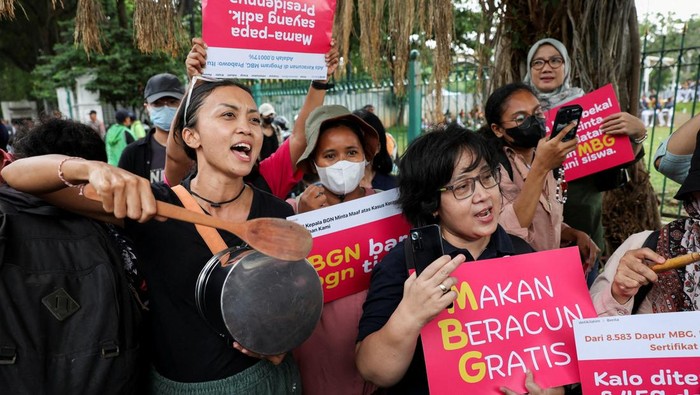 People carry placards and utensils during a protest against the government's free meal programme in Jakarta, Indonesia, October 1, 2025. REUTERS/Ajeng Dinar Ulfiana