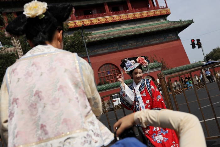 Visitors walk past a Chinese flag decorating a shop in the Shichahai area on National Day, the first day of Chinas eight-day Golden Week holiday, in Beijing, China October 1, 2025. REUTERS/Florence Lo