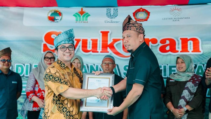 Auditor RSPO Naik Monang P. Lingga (kiri) menyerahkan sertifikasi RSPO kepada Ketua KUD Makarti Jaya Hadi Yanto (Dok Humas PTPN IV)