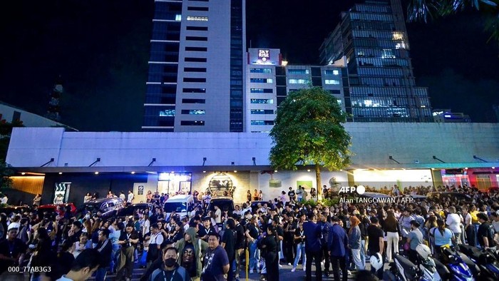 Karyawan pusat panggilan sibuk bermain ponsel saat berkumpul di luar gedung kantor setelah gempa bumi mengguncang Cebu, Filipina tengah, pada 30 September 2025. Gempa magnitudo 6,9 mengguncang lepas pantai Filipina tengah pada malam 30 September, menurut Survei Geologi AS.
