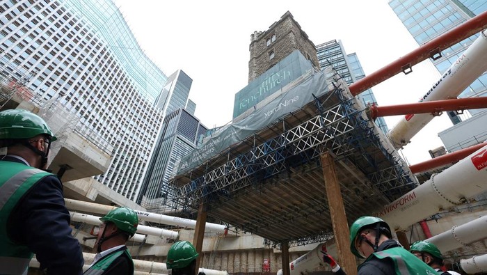Site visitors view the tower of All Hallows Staining, a 700-year-old medieval church tower, which has been temporarily elevated 14 metres above ground level, as developers prepare to integrate it into the new office building project of 50 Fenchurch Street, in the City of London financial district, in London, Britain, September 23, 2025. REUTERS/Toby Melville TPX IMAGES OF THE DAY