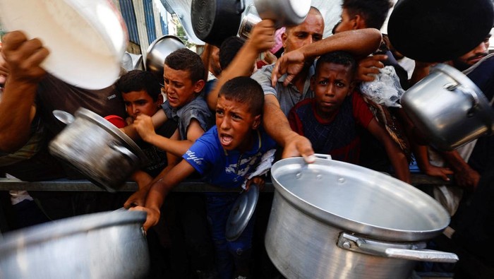 Potret Warga Palestina Padati Dapur Umum untuk Bertahan Hidup Palestinians gather to receive food from a charity kitchen, in Nuseirat, central Gaza Strip, September 28, 2025. REUTERS/Mahmoud Issa
