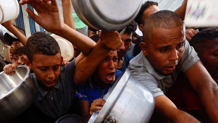 Potret Warga Palestina Padati Dapur Umum untuk Bertahan Hidup Palestinians gather to receive food from a charity kitchen, in Nuseirat, central Gaza Strip, September 28, 2025. REUTERS/Mahmoud Issa