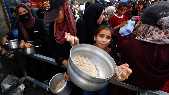 Palestinians gather to receive food from a charity kitchen, in Nuseirat, central Gaza Strip, September 28, 2025. REUTERS/Mahmoud Issa