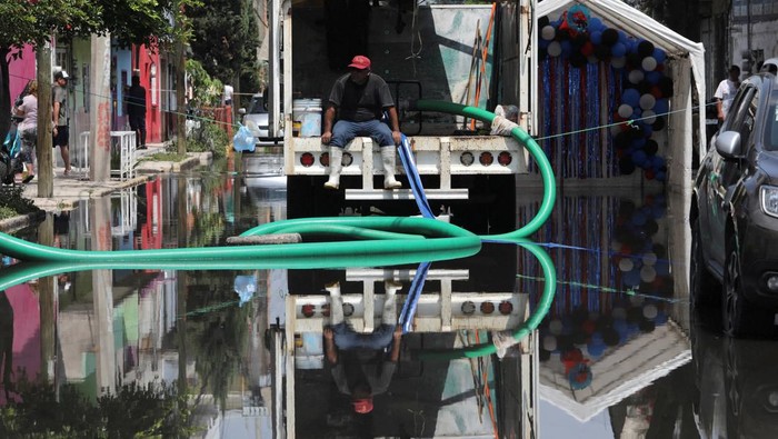 Warga di wilayah Meksiko tengah masih berjibaku membersihkan rumah dan jalanan setelah banjir besar melanda kawasan tersebut pada Selasa (30/9/2025). Hujan deras yang mengguyur selama berjam-jam disebut sebagai salah satu yang terparah dalam beberapa dekade terakhir. REUTERS/Paola Garcia