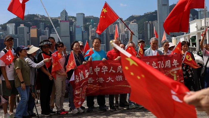 Suasana perayaan Hari Nasional Tiongkok ke-76 terasa meriah di Hong Kong pada Rabu (1/10/2025). Sejumlah warga pro-Tiongkok turun ke jalan sambil membawa dan mengibarkan bendera nasional Tiongkok sebagai bentuk dukungan serta kebanggaan mereka terhadap Tanah Air. REUTERS/Tyrone Siu