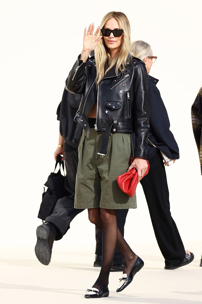 Saat berpose di depan para kamerawan, Charlize menambahkan kacamata hitam yang melengkapi gaya edgy tersebut. Adapun purse merah dan loader berpita yang menyempurnakan penampilan peraih Oscar itu. Foto: Getty Images/Claudio Lavenia