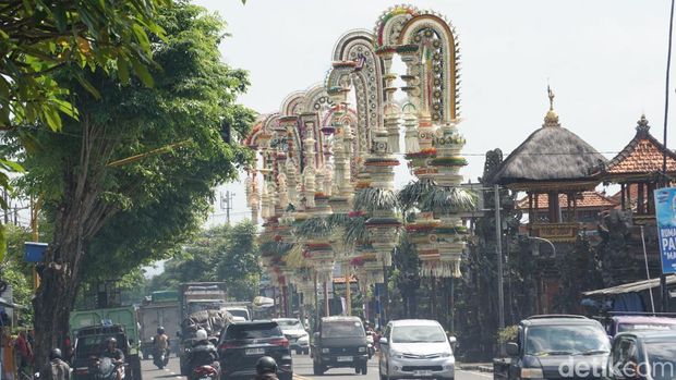 Belasan penjor dengan beragam ornamen berdiri megah di sepanjang jalan depan Pura Desa Adat Kapal, Kecamatan Mengwi, Badung, Kamis pagi (2/10/2025). (Agus Eka/detikBali)