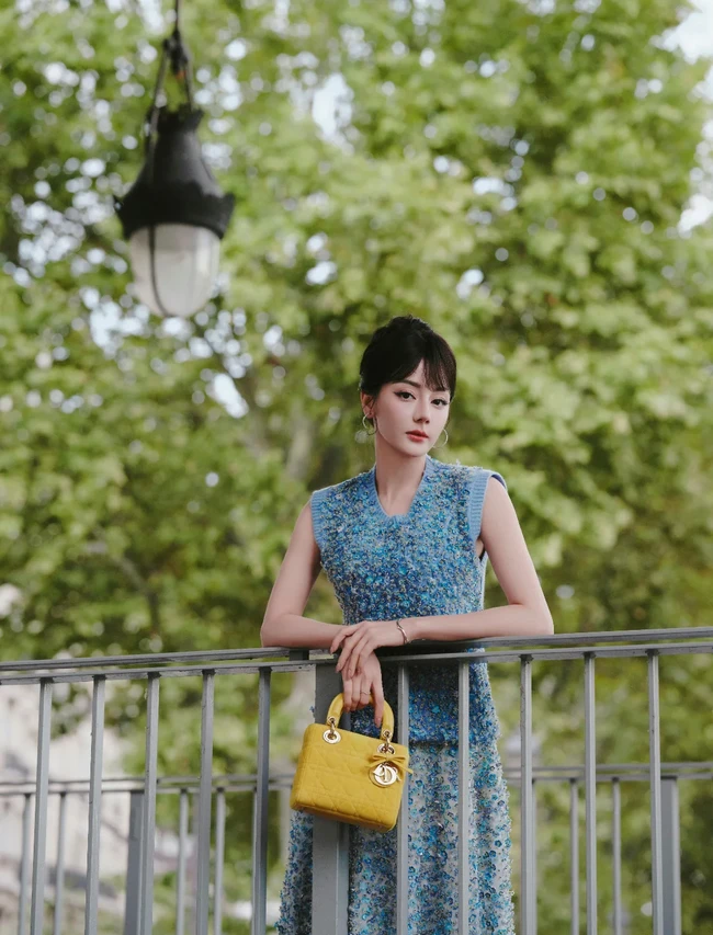 Tas Lady Dior berwarna kuning lemon melengkapi penampilannya dan tampak kontras dengan busananya yang serba biru. Foto: Dok. Dilrabas Studio