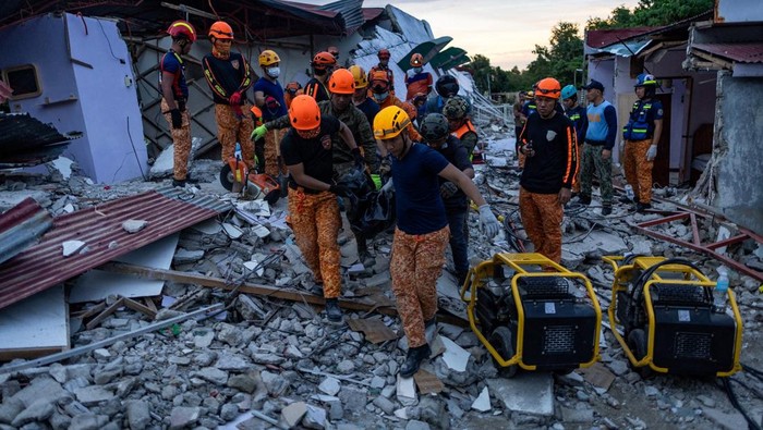 Rescuers carry a victim's body recovered from a damaged pension house in the aftermath of a magnitude 6.9 quake in Bogo, Cebu, Philippines, October 1, 2025. REUTERS/Eloisa Lopez  REFILE - QUALITY REPEAT