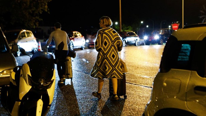 Tourists walks past a flooded street after storm Gabrielle hit the island in Ibiza, Spain September 30, 2025. REUTERS/Francisco Ubilla