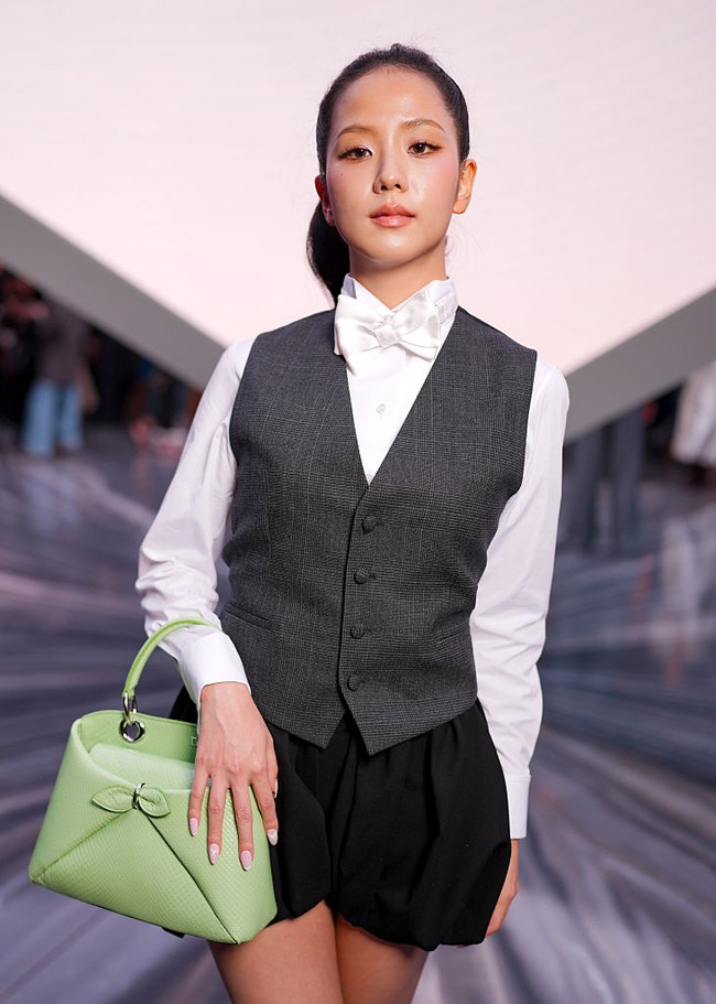 Jisoo BLACKPINK menunjukkan eksistensinya sebagai perwakilan Dior di Paris Fashion Week 2025. Tampil beda dengan gaya preppy, berbalut kemeja putih dilapisi rompi hitam, dasi kupu-kupu, dan celana pendek model balon. Tatanan rambutnya menambah kesan chic dengan model sleek ponytail. Foto: dok. Getty Images