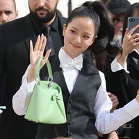 Pelantun ‘FLOWER’ itu melengkapi penampilannya dengan pump heels hitam dan koleksi tas Dior berwarna hijau pastel, yang menjadi fashion statement. Foto: dok. Getty Images