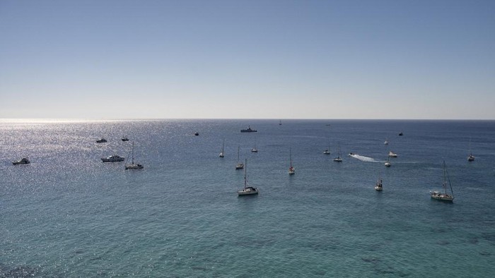 A group of ships of the Global Sumud Flotilla to Gaza are shown moored at the small island of Koufonisi, south of the island of Crete on September 26, 2025. After a reported attack by drones early on September 25, 2025 morning, Athens has said it will guarantee safe sailing in its waters. The Global Sumud Flotilla, carrying activists including Swedish environmentalist Greta Thunberg, blamed Israel for more than a dozen explosions heard around its vessels off Greece late on September 24, 2025. (Photo by Eleftherios ELIS / AFP)