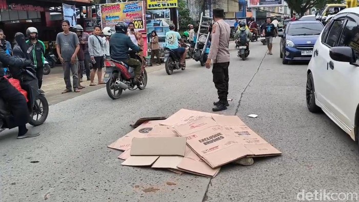 Jenazah korban ditutup kardus sebelum dievakuasi petugas.