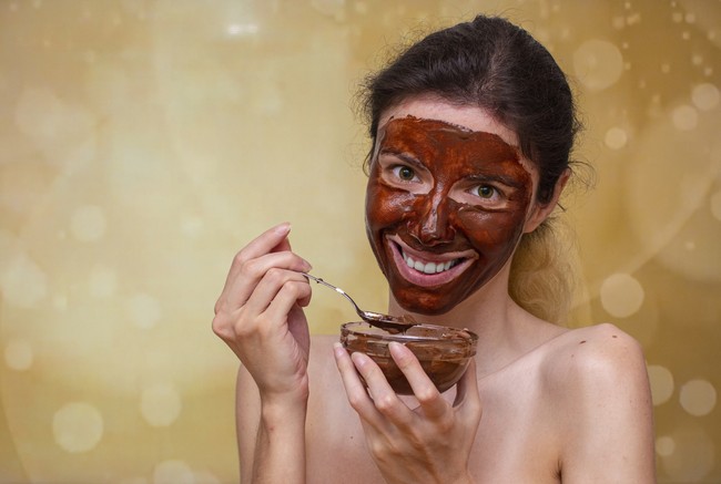 Wanita memakai masker cokelat di wajah.