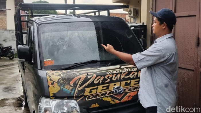 Reza saat menunjukkan kaca mobilnya yang dipecahkan sopir Xenia