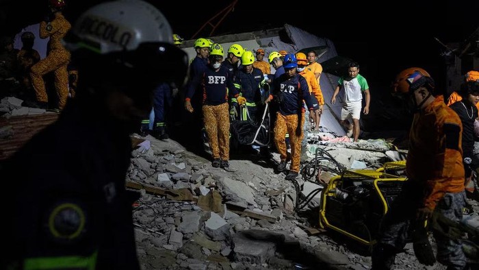 Rescuers carry the body bag of a victim recovered from a damaged pension house in the aftermath of a magnitude 6.9 quake in Bogo, Cebu, Philippines, October 1, 2025. REUTERS/Eloisa Lopez Purchase Licensing Rights