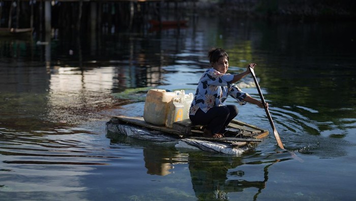 Seorang ibu suku Bajo melintas membawa air bersih menggunakan jeriken di atas sampan di Desa Nelayan Bakti, Wakatobi, Sulawesi Tenggara, Jumat (3/10/2025). Beberapa warga suku Bajo masih membeli aliran air bersih seharga Rp1000 per jeriken berukuran 6 liter sebab distribusi air ke rumah warga belum merata. ANTARA FOTO/Jojon/rwa.