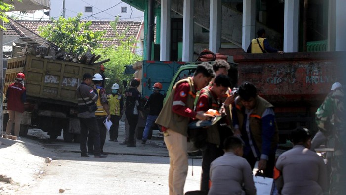 Petugas berjaga didekat truk yang membawa material bangunan musala yang ambruk di Pondok Pesantren (Ponpes) Al Khoziny di Kecamatan Buduran, Sidoarjo, Jawa Timur, Kamis (2/10/2025). Pembongkaran bangunan tersebut untuk memudahkan akses tim evakuasi ke korban yang diduga masih banyak yang belum terselamatkan. ANTARA FOTO/Umarul Faruq/agr