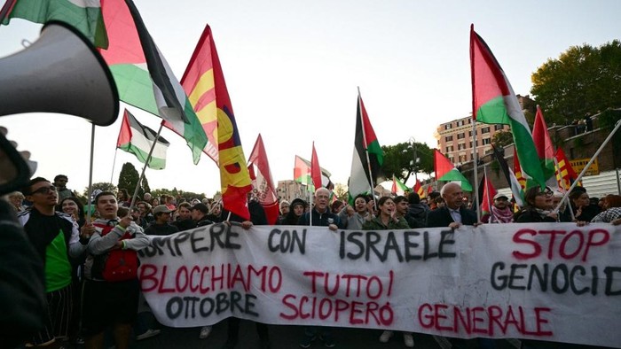 Pro-Palestinian demonstrators march behind a banner Stop Genocide- Lets block everything - General Strike to support the Palestinians and to protest against the interception of the Global Sumud Flotilla, near the Colosseum in Rome on October 2, 2025. (Photo by Tiziana FABI / AFP)