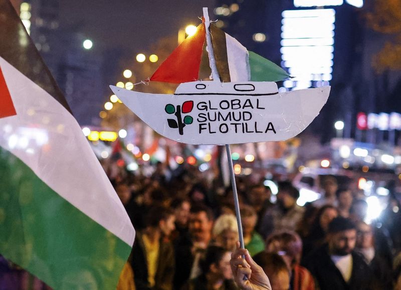 Pro-Palestinian demonstrators march behind a banner 