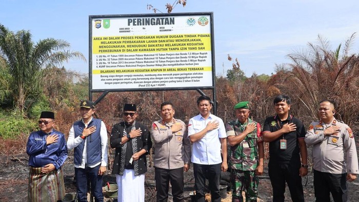 Kapolres Pelalawan AKBP John Louis Letedara memasang plang larangan aktivitas di lahan bekas karhutla, Jumat (3/10/2025).