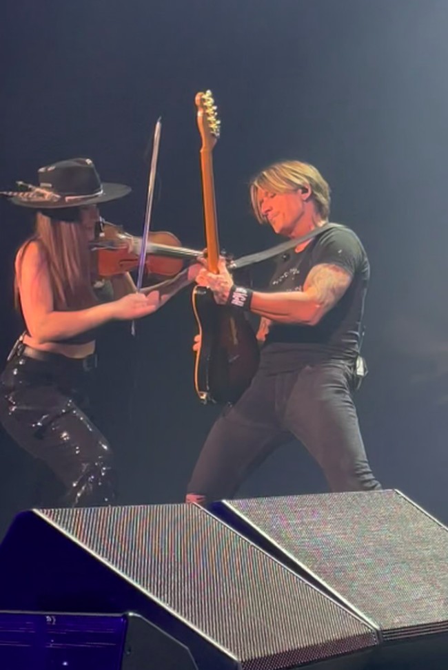 Dalam video, Keith menyanyikan lirik “I was born to love you” selagi melihat dan menunjuk Maggie. Ia juga mengganti lirik “When they’re tryna get to you, baby, I’ll be the fighter” menjadi “When they’re tryna get to you, Maggie, I’ll be your guitar player.” Foto: Instagram Maggie Baugh