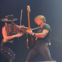 Dalam video, Keith menyanyikan lirik “I was born to love you” selagi melihat dan menunjuk Maggie. Ia juga mengganti lirik “When they’re tryna get to you, baby, I’ll be the fighter” menjadi “When they’re tryna get to you, Maggie, I’ll be your guitar player.” Foto: Instagram Maggie Baugh