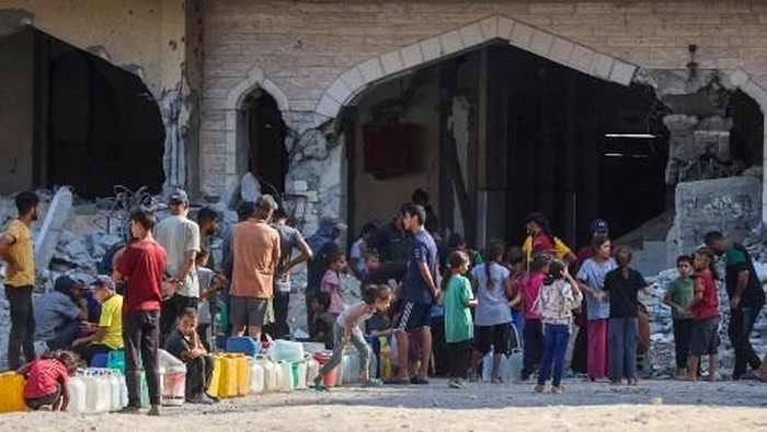Palestinians displaced by the conflict queue up to collect water at the Qatari-built Hamad City residential complex in northwestern Khan Yunis, in the southern Gaza Strip, on September 24, 2025. In recent weeks, the Israeli military has launched a heavy air and ground assault on the Gaza Strip, an effort it says is aimed at eliminating Hamas fighters from the Palestinian territorys largest urban hub. (Photo by Omar AL-QATTAA / AFP)