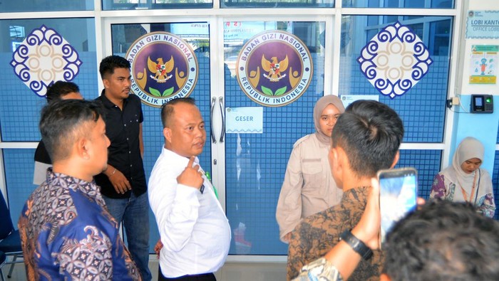 Petugas berada di depan dapur Satuan Pelayanan Pemenuhan Gizi (SPPG) di Nagari Kampuang Tangah, Lubuk Basung, Agam, Sumatera Barat, Kamis (2/10/2025). Pemprov Sumbar bersama Satuan Tugas (Satgas) Percepatan Penyelenggaraan MBG menghentikan sementara operasional dapur tersebut karena belum memiliki izin resmi kelaikan dari pemerintah dan diduga menyebabkan 110 orang terindikasi keracunan makanan.
 ANTARA FOTO/Iggoy el Fitra/agr