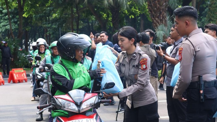 Polwan turun langsung membagikan sembako kepada ojol di Polda Metro Jaya.
