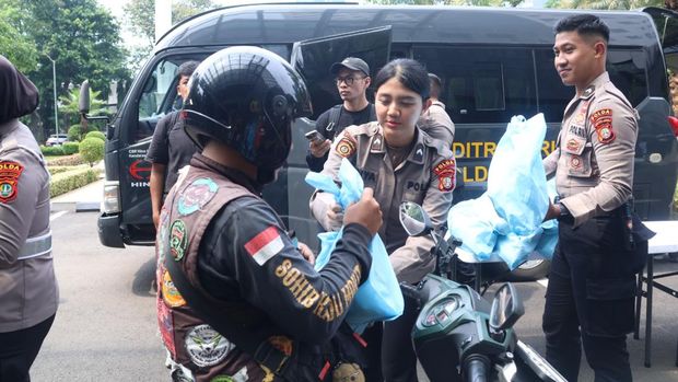Polwan turun langsung membagikan sembako kepada ojol di Polda Metro Jaya.