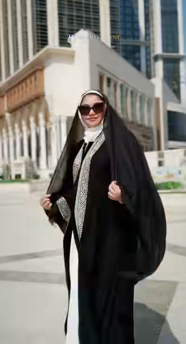 Penampilannya dilengkapi dengan hijab panjang hitam transparan (flowy) yang menyatu dengan abaya. Wajahnya tampak cantik natural tanpa riasan. Foto: Instagram/@sazarita