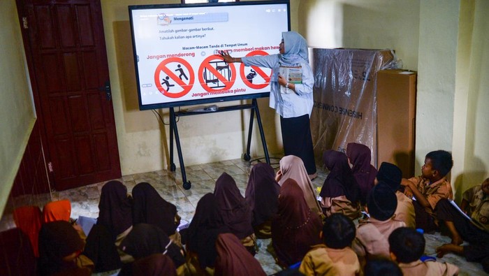 Guru menyampaikan materi pelajaran melalui papan interaktif atau layar digital pintar (Interactive Flat Panel) di SD Negeri Panunggulan 2, Kabupaten Serang, Banten, Jumat (3/10/2025). Sejumlah sekolah dasar di Kabupaten Serang mulai menggunakan layar digital pintar yang merupakan program bantuan Pemerintah Pusat sebagai upaya mengatasi kesenjangan dalam penyelenggaraan sarana pendidikan baik di daerah perkotaan maupun daerah pelosok. ANTARA FOTO/Muhammad Bagus Khoirunas/rwa.