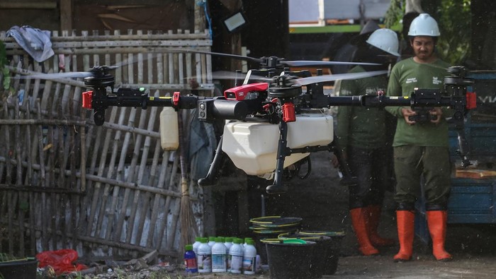 Operator dari Maxxi Tani menerbangkan pesawat tanpa awak atau drone untuk menyemprotkan pestisida di area persawahan Desa Tanara, Kecamatan Tanara, Kabupaten Serang, Banten, Rabu (1/10/2025). Kelompok tani Sukamaju, Desa Tanara mulai menggunakan teknologi drone pertanian untuk penyemprotan pestisida sebab dinilai lebih efektif dan efisien jika dibandingkan cara konvensional karena hanya membutuhkan waktu rata-rata 15 menit untuk satu hektare lahan dengan tarif Rp550 ribu-Rp600 ribu termasuk larutan pestisida per hektarenya. ANTARA FOTO/Angga Budhiyanto/foc.