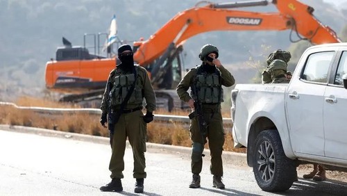 Israeli soldiers stand guard during the construction of Israeli bypass road infrastructure, near Ramallah, in the Israeli-occupied West Bank, September 29, 2025. (Reuters)