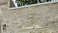 Berfoto di depan gerbang masuk Taman Doa Kasih Mulia Sejati