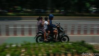 Beberapa pemotor tampak berboncengan tiga saat melintas di jalur sepeda kawasan Perintis Kemerdekaan. Aksi berbahaya ini berpotensi menimbulkan kecelakaan lalu lintas.