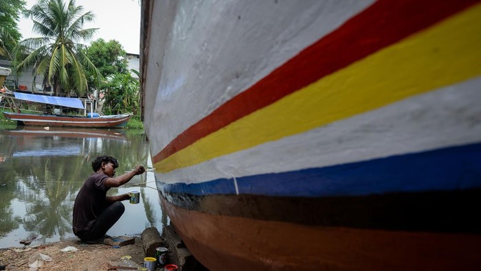 Pekerja menyelesaikan perbaikan perahu nelayan di Desa Karang Serang, Kabupaten Tangerang, Banten, Selasa (30/9/2025). Menurut pekerja jasa perbaikan perahu berupa pengecatan, penambalan hingga penggantian kayu tersebut berkisar Rp15 juta - Rp30 juta per unitnya tergantung jenis kerusakan dan ukuran perahu. ANTARA FOTO/Putra M. Akbar/rwa.