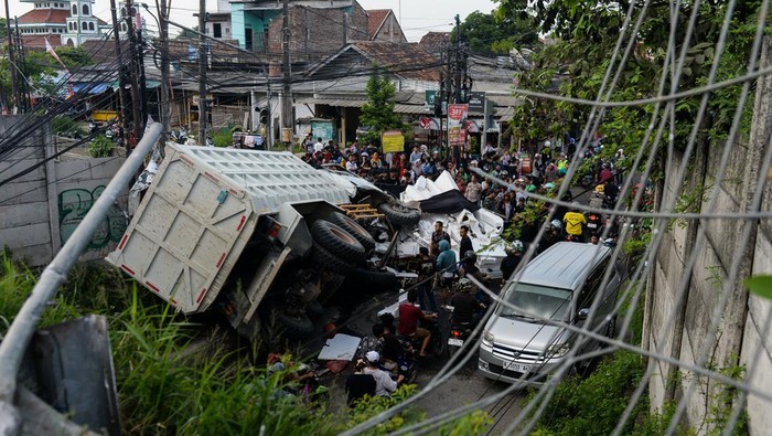 Kondisi truk yang rusak akibat terjun dari ruas tol Tangerang-Merak di Kaligandu, Kota Serang, Banten, Sabtu (4/10/2025). Kecelakaan truk tronton bernomor polisi B 9235 KIS yang melaju dari arah Tangerang menuju Merak tersebut diduga akibat sopir mengantuk sehingga mengakibatkan truk terjun bebas hingga ke underpass pas tol pada pukul 14.00 WIB dan menyebabkan dua kendaraan tertimpa, serta lima orang dilarikan ke rumah sakit. ANTARA FOTO/Muhammad Bagus Khoirunas/nz