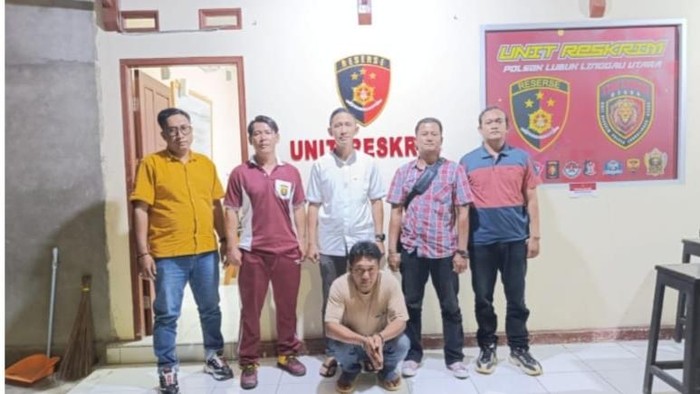 Asnawi (duduk) yang aniaya pacarnya saat diamankan polisi