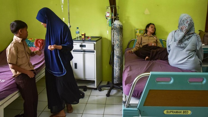 Orang tua mendampingi anaknya saat dirawat di Puskesmas Kawali, Kabupaten Ciamis, Jawa Barat, Jumat (3/10/2025). Sebanyak 16 siswa dari SD Negeri 1 Sindangsari, MI PUI Pogorsari, dan SD Negeri 5 Karangpawitan, mengalami keracunan yang diduga akibat menyantap hidangan Makan Bergizi Gratis (MBG). ANTARA FOTO/Adeng Bustomi/YU