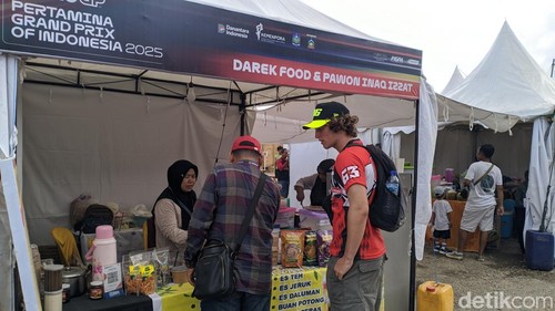 Seorang WNA membeli produk UMKM di stand Festival Lombok Sumbawa Fair di dalam Sirkuit Mandalika, Sabtu (4/10/2025). (Foto: Ahmad Viqi/detikBali)