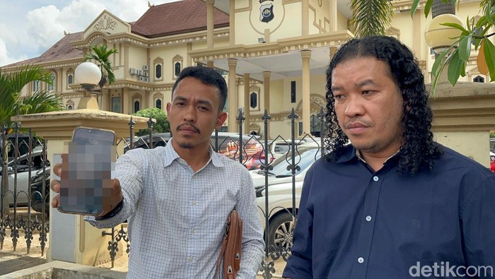 Kuasa hukum keluarga Aryadi yang tewas ditembak mati polisi menunjukan foto kondisi korban usai menghadiri undangan gelar perkara Bidang Propam Polda Jambi